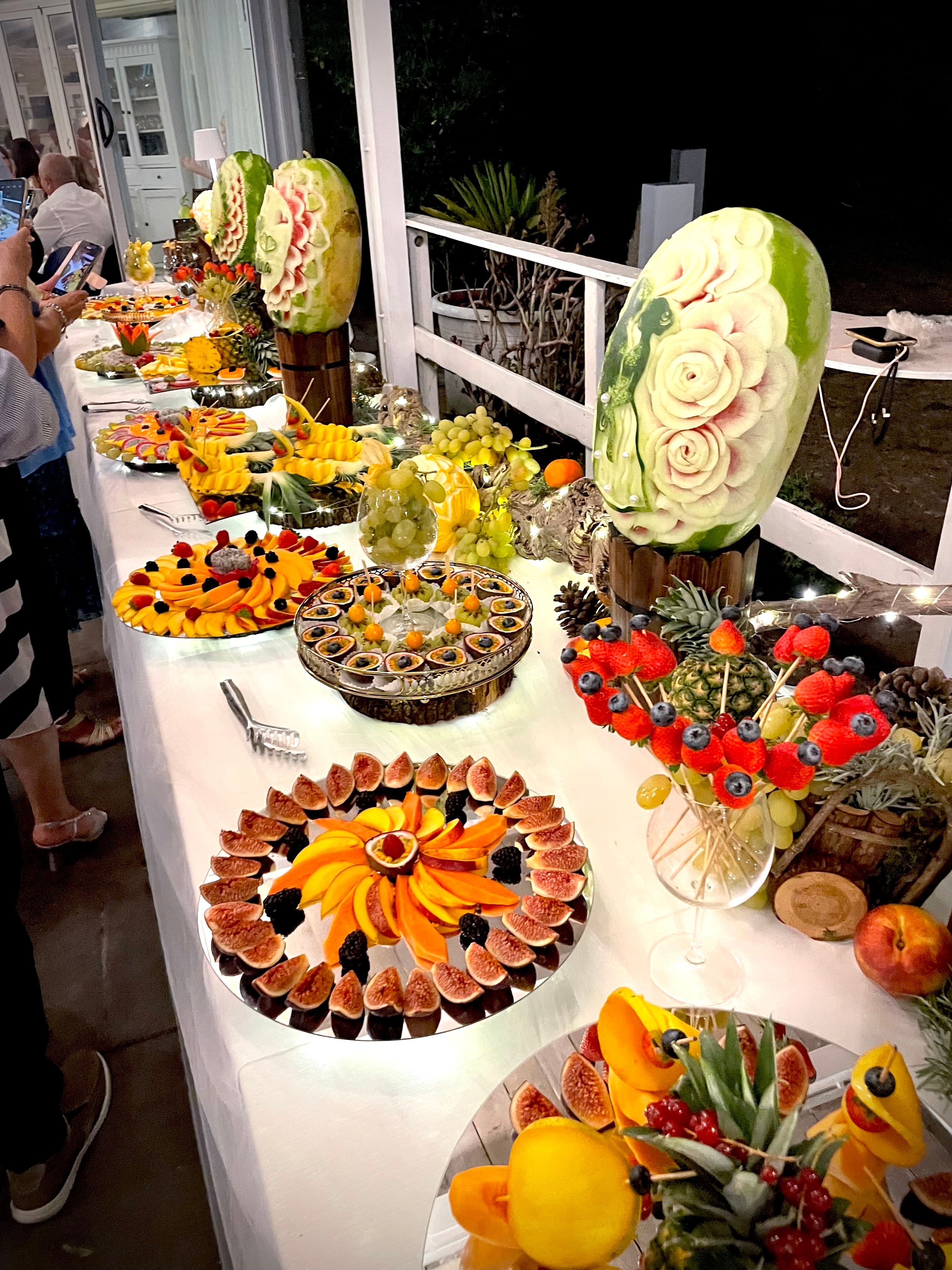 Buffet di frutta scenografico per matrimonio di sera in Sardegna con due sculture monumentali su anguria