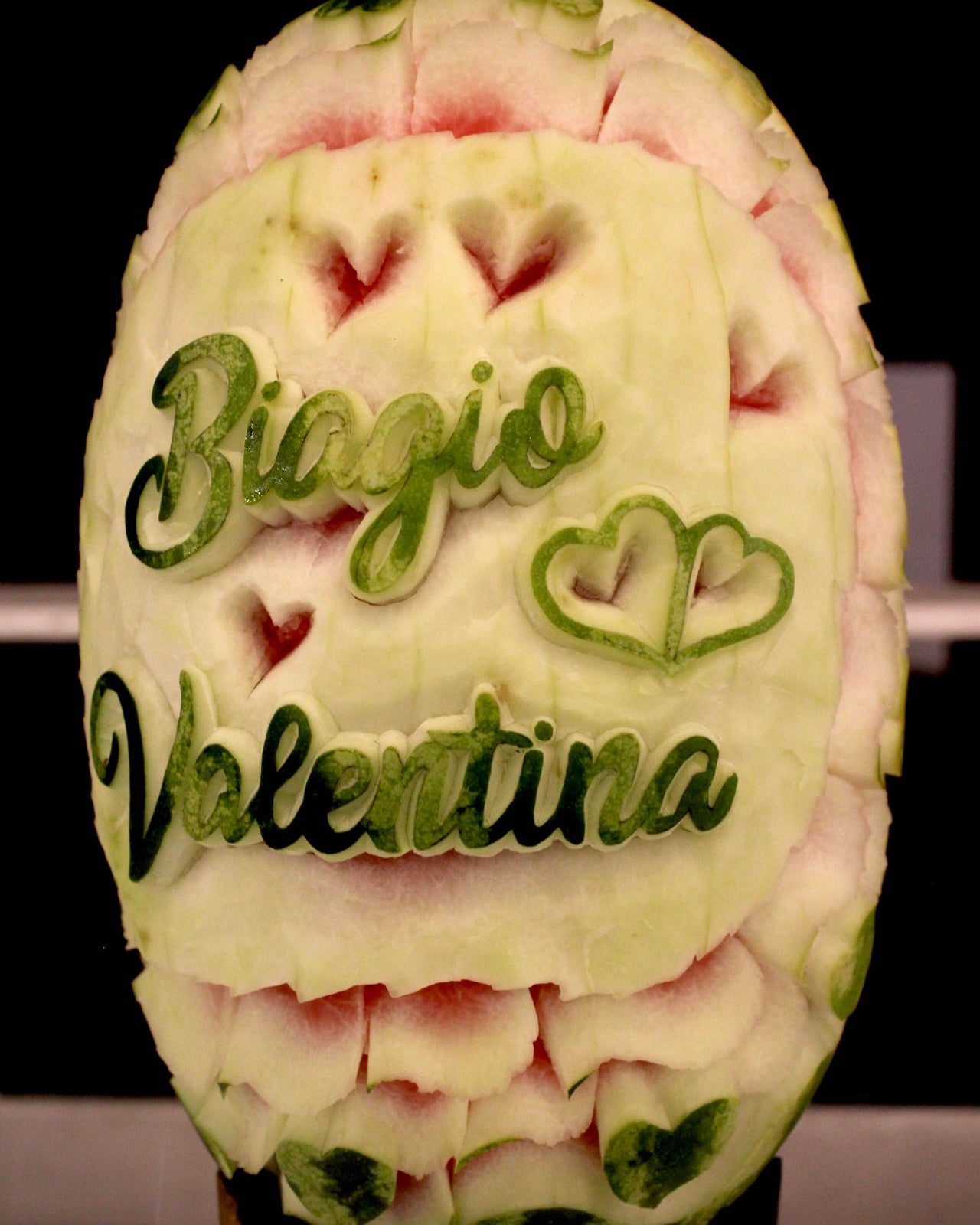 Scultura su anguria con nomi degli sposi in lettering corsivo per buffet matrimoniale
